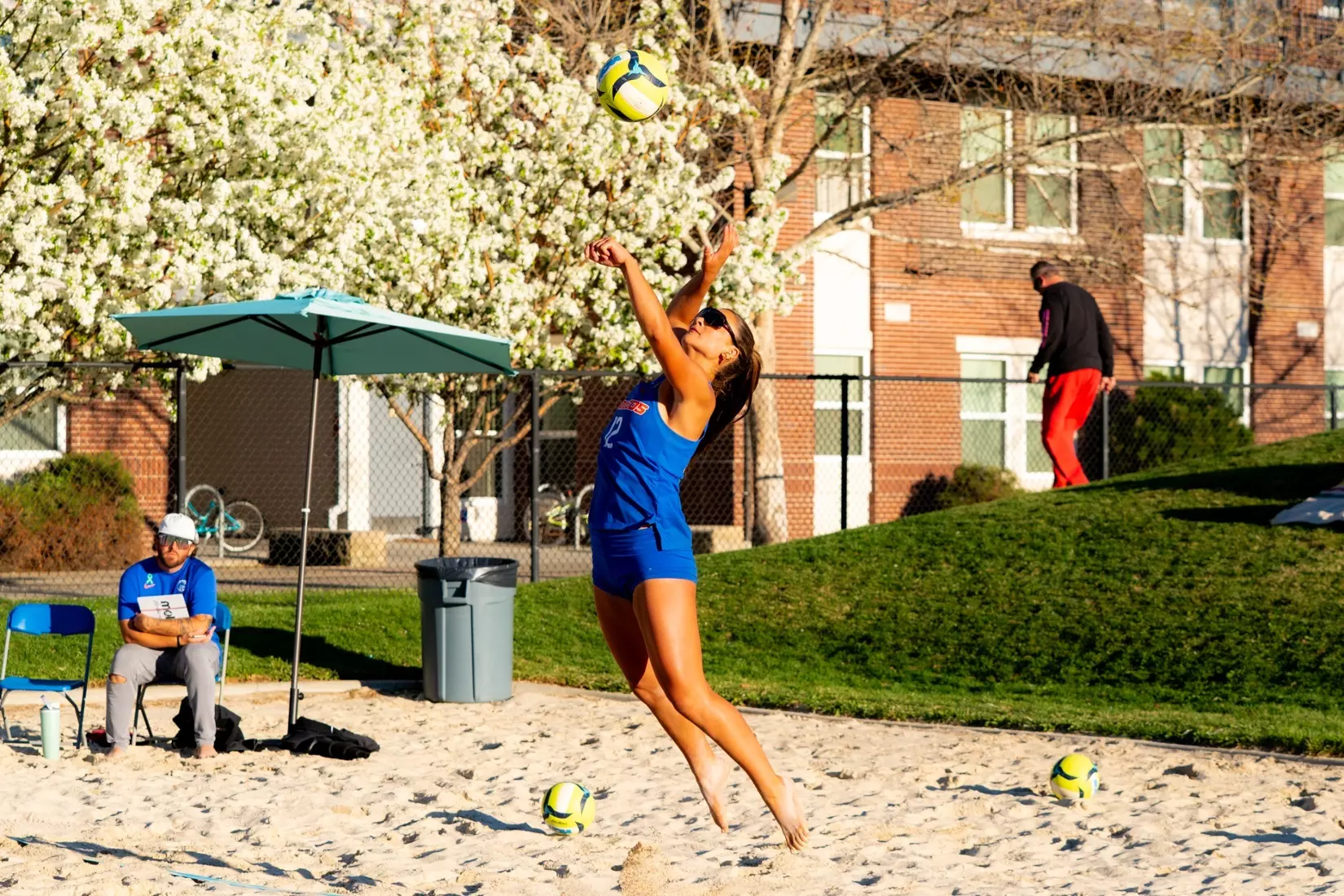 Beach volleyball player tossing for a jump serve on the sand