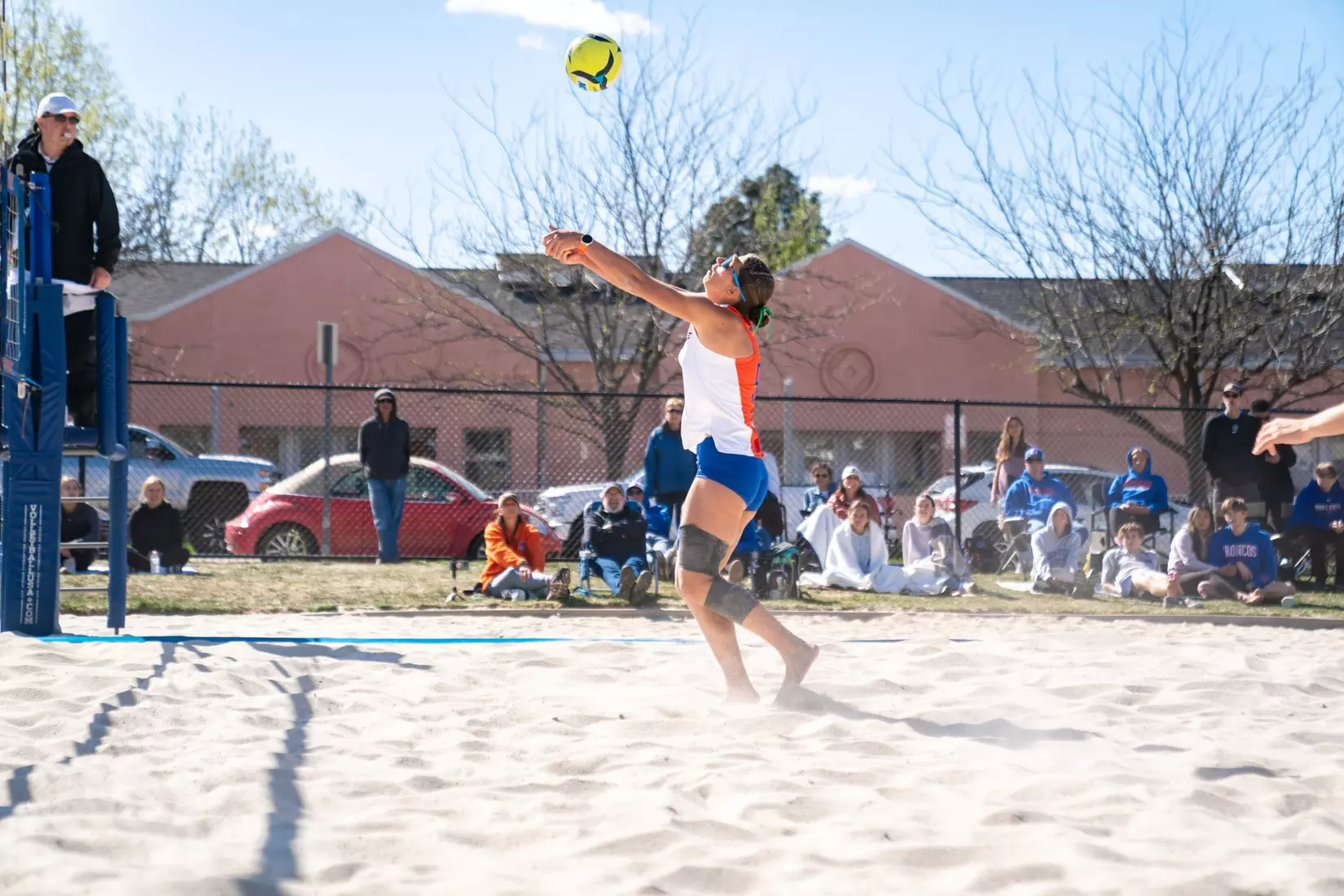 Beach volleyball player swinging at the net during a competitive rally