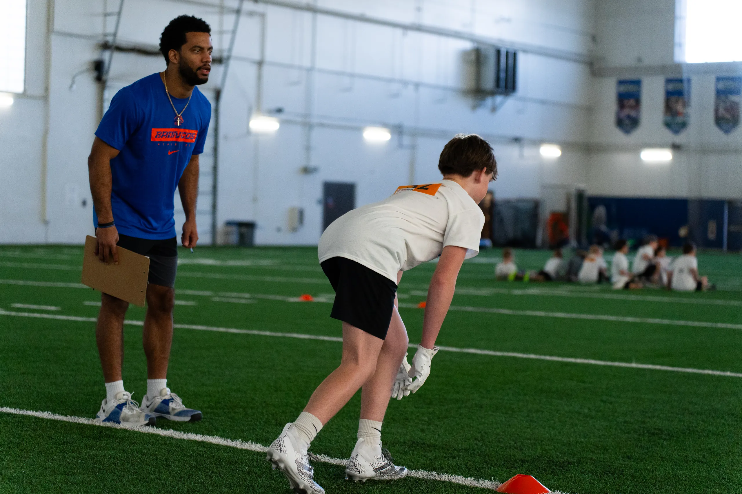 Boise State player coaching a camper at a past Horseshoe football camp