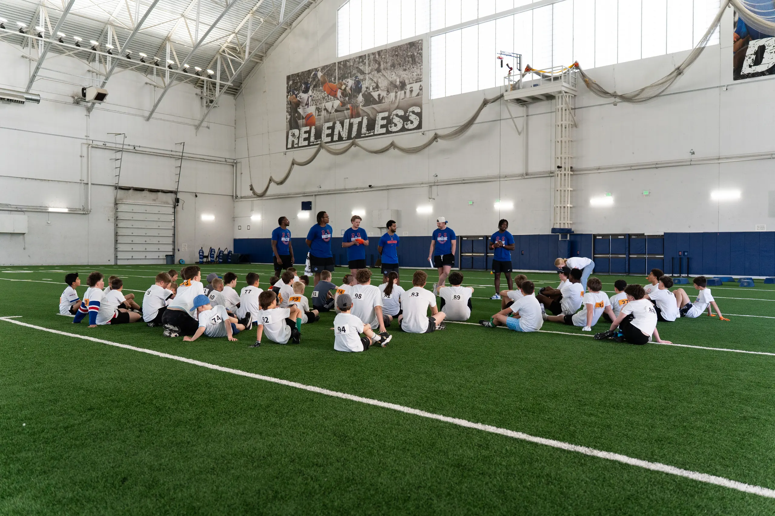 Camper training with a Boise State player at a past Horseshoe football camp