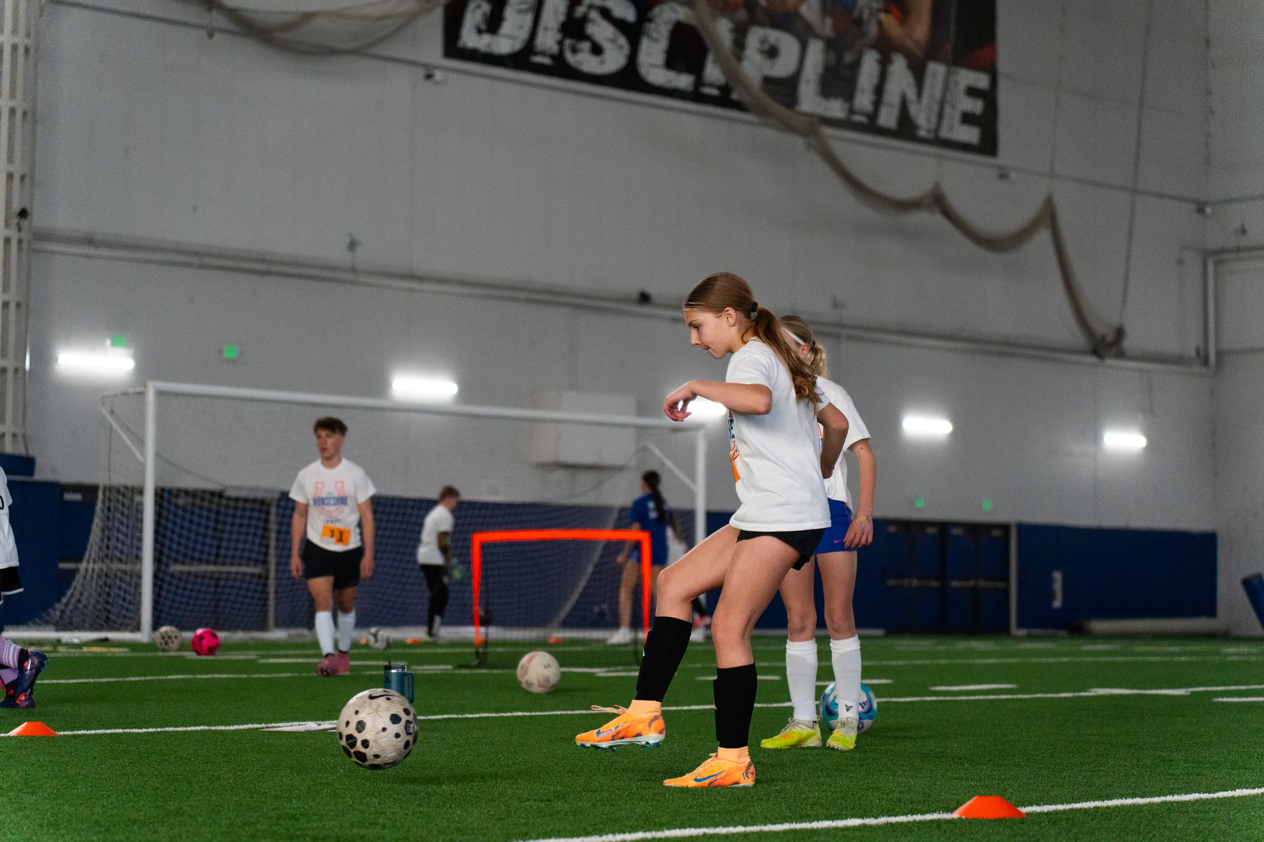 Camper lining up a strike in front of the goal at a past Horseshoe soccer camp