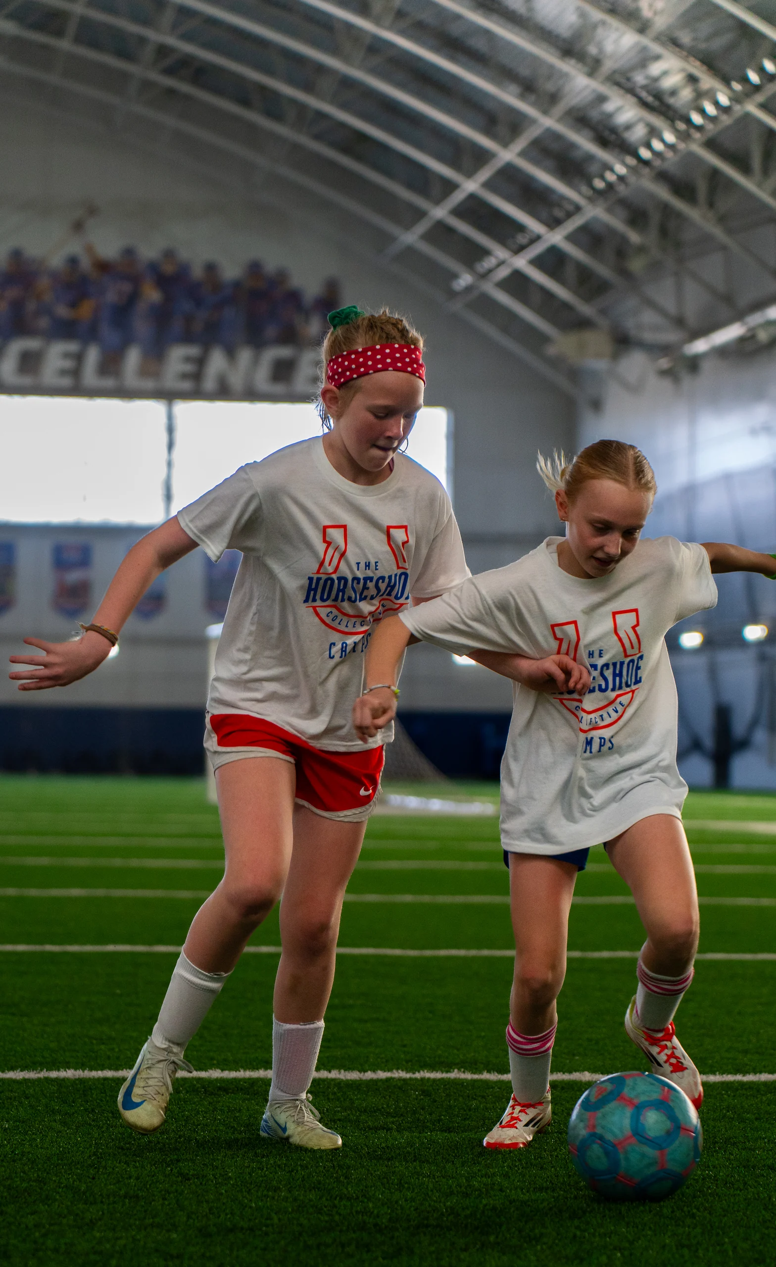 Two campers battling for possession on the indoor turf