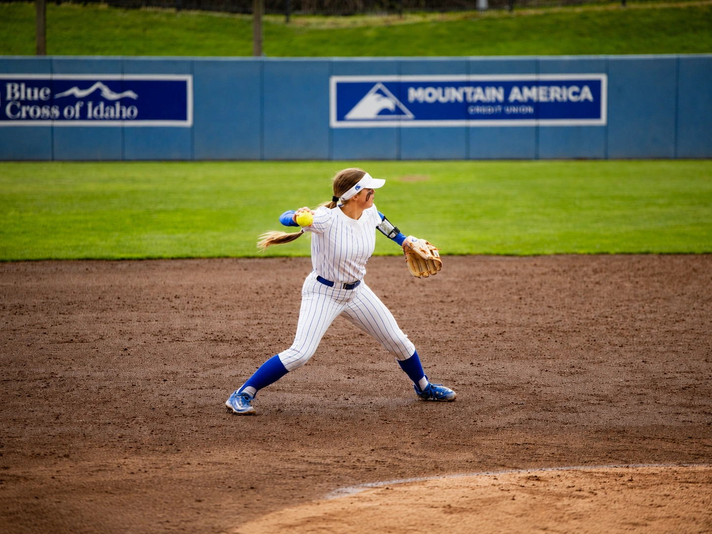 Boise State Softball infielder throwing across the diamond
